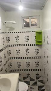 uma casa de banho com um WC branco e azulejos pretos e brancos. em Casa 2 Quartos Manaus em Manaus