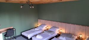 a bedroom with two beds with lights on the wall at Willa Imprezja in Zduńska Wola