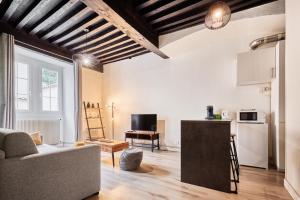 sala de estar con sofá y cocina en L'authentique Bressan en Bourg-en-Bresse