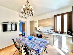 eine Küche und ein Esszimmer mit einem Tisch und Stühlen in der Unterkunft Casa Marzia by Housilia in Cefalú