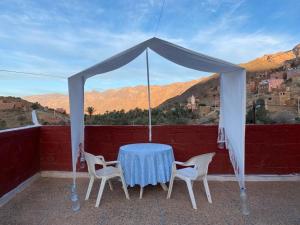 een tafel met stoelen en een tent met uitzicht bij iskki-asnfou in Tafraoute