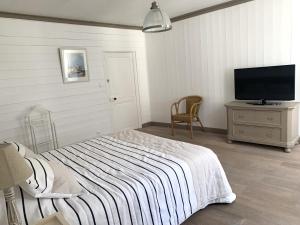 a bedroom with a bed and a flat screen tv at Appartement Sully in Saint-Martin-de-Ré