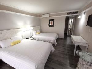 Cette chambre comprend 2 lits et une table. dans l'établissement Paraíso Express, à Torreón