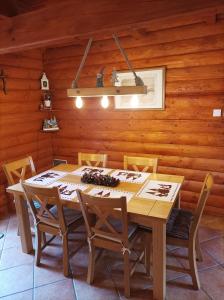 a wooden dining room with a wooden table and chairs at Blidinjehouse in Risovac