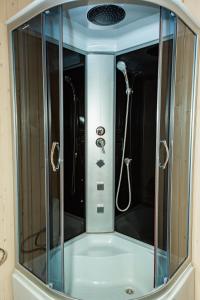 a shower with a glass enclosure in a bathroom at Мігалі in Dragobrat
