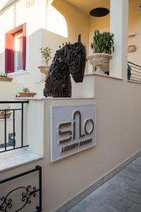 a sign for a library house with a horse statue at Silo Luxury Rooms in Nafplio