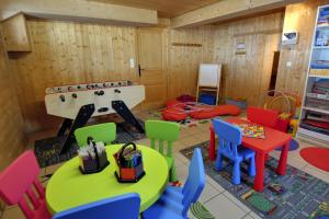 ein Kinderspielzimmer mit bunten Stühlen und Tischen in der Unterkunft Chalet Les Grolets - Ardent in Montriond