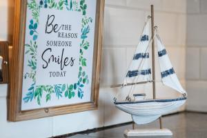 a wooden toy sailboat on a table next to a sign at New - Stylish 4 bedroom House, Business & Leisure. Discount on long stays. By Jesswood Properties. in Southend-on-Sea