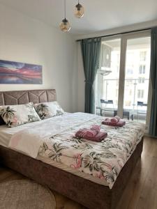 a bedroom with a bed with pink towels on it at Skyview City Apartment in Skopje