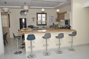 a kitchen with bar stools and a counter top at Apparemment chic et lumineux in Dassasgo
