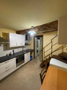 una cocina con armarios blancos y una escalera en una habitación en bilocale arredato sestri ponente, en Génova