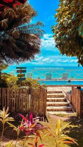 a view of a beach with a wooden fence and stairs at Pousada Portal dos Coqueirais in Jequia da Praia