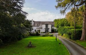 a house with a green lawn in front of it at Plas Dolguog in Machynlleth