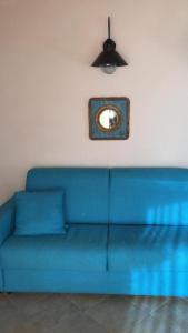 niebieska kanapa przy białej ścianie z lustrem w obiekcie Oasi Turchese Sardegna w mieście Trinità dʼAgultu