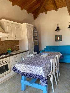 kuchnia ze stołem z niebieską tkaniną w obiekcie Oasi Turchese Sardegna w mieście Trinità dʼAgultu