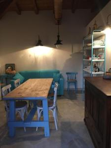 salon ze stołem i niebieską kanapą w obiekcie Oasi Turchese Sardegna w mieście Trinità dʼAgultu