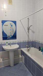 une salle de bains avec lavabo et baignoire dans l'établissement Студия в центре, à Astana