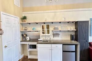 a kitchen with white cabinets and a counter top at Haven at Hazel~Downtown Bungalow in Demorest +21 photos