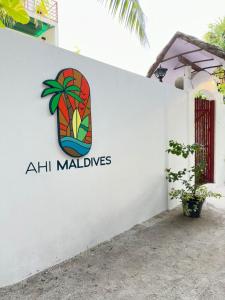 un cartello sul lato di un edificio bianco di AHI Maldives a Omadhoo