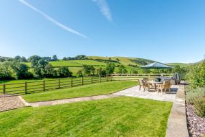 a patio with a table and chairs and an umbrella at Waun Yscir Rural escape in the Brecon Beacons in Brecon