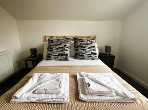 a bedroom with a bed with towels on it at Temperance in Freshwater