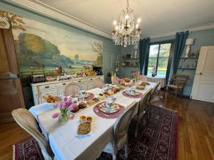 un comedor con una mesa con comida. en La plaine de l'Angelus en Chailly-en-Bière