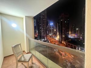 Hostel Resort VIP في دبي: كرسي على شرفة مطلة على مدينة