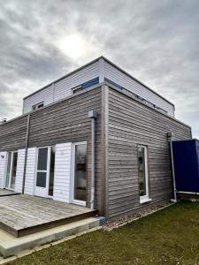 une petite maison avec un porche en bois dans une cour dans l'établissement Ferienhaus Michel, à Butjadingen
