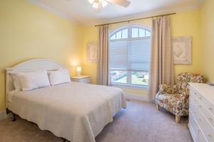 um quarto com uma cama, uma cadeira e uma janela em Ohana House em Carolina Beach