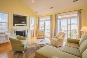 uma sala de estar com um sofá e cadeiras e uma lareira em Ohana House em Carolina Beach