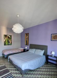 ローマにあるCASA UMBERTOの紫の壁のベッドルーム1室(ベッド2台付)