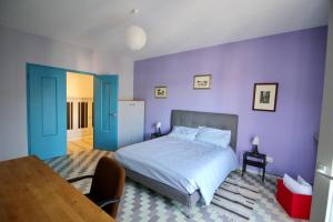 ローマにあるCASA UMBERTOの紫の壁のベッドルーム(ベッド1台、テーブル付)