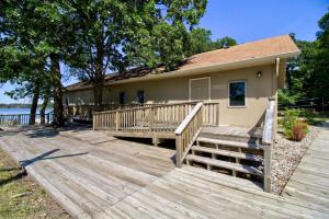 a house with a large wooden deck in front of it at Escape to a Studio Style Hideaway Nature and Lake in Clitherall