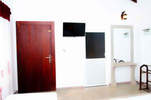 um quarto com uma porta vermelha e uma televisão em Mandavilla Airport Transit Hotel em Demanhandiya