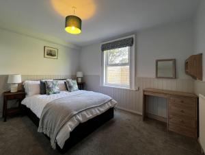 a bedroom with a bed and a window at The Cottage, Shalfleet House in Shalfleet