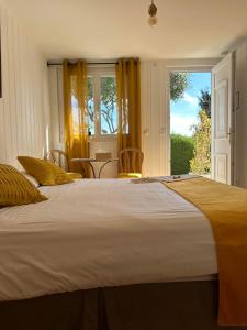 a bedroom with a large bed and a window at Hôtel La Fiancée du Pirate in Villefranche-sur-Mer