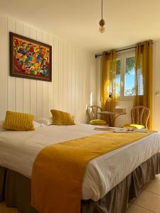 a bedroom with a large bed with yellow pillows at Hôtel La Fiancée du Pirate in Villefranche-sur-Mer