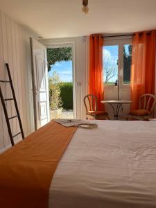 a bedroom with a large bed with an open door at Hôtel La Fiancée du Pirate in Villefranche-sur-Mer