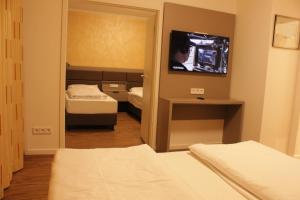 慕尼黑的住宿－Isar City Hotel，客房设有两张床、一台电视和镜子