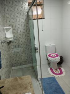 a bathroom with a toilet and a glass shower at Casa da Vó Bia in Alto Caparao