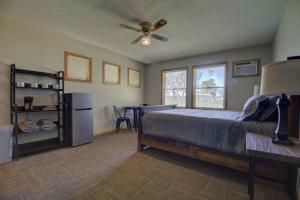 - une chambre avec un lit et un ventilateur de plafond dans l'établissement Spitzer Lake Escape to a Studio Style Cottage, à Clitherall
