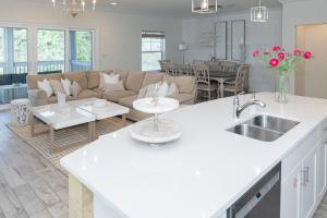 a kitchen and living room with a couch and a table at New Listing, Luxury 4bd Steps to Beach Club in Pensacola