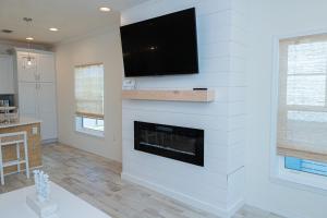 a living room with a fireplace with a flat screen tv at New Listing, Luxury 4bd Steps to Beach Club in Pensacola