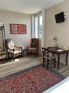 a living room with chairs and a table and a tv at Hôtel La Fiancée du Pirate in Villefranche-sur-Mer