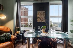 ein Esszimmer mit Glastisch und Stühlen in der Unterkunft Stylish 2 Bed Apartment Near Beach, Parking, Wifi, Netflix in Teignmouth