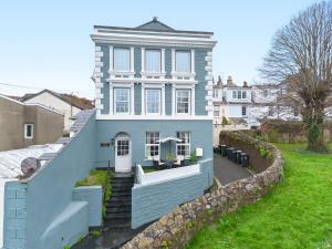 a blue house with a retaining wall at Stylish 2 Bed Apartment Near Beach, Parking, Wifi, Netflix in Teignmouth