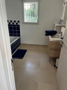 ein Bad mit einer Badewanne, einem Waschbecken und einem Fenster in der Unterkunft La villa Rosa in Bédoin