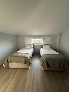 2 Betten in einem kleinen Zimmer mit Fenster in der Unterkunft Casa do Sorrio in Viana do Castelo