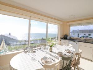 uma sala de jantar com uma mesa e vista para o oceano em Sea's The Dream em Clonakilty