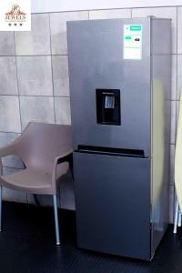 um pequeno frigorífico com uma cadeira ao lado em JFT self catering units em East London